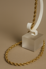 Load image into Gallery viewer, Gold chain on a white stand against a beige background