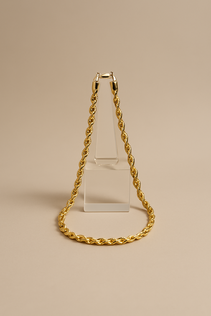 Gold chain necklace on a beige background