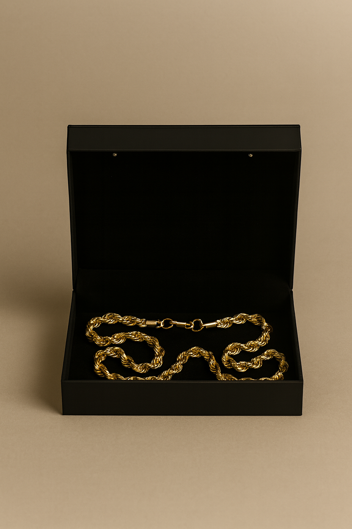Gold chain in a black box on a beige background