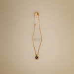 Load image into Gallery viewer, Gold necklace with a pendant on a beige background
