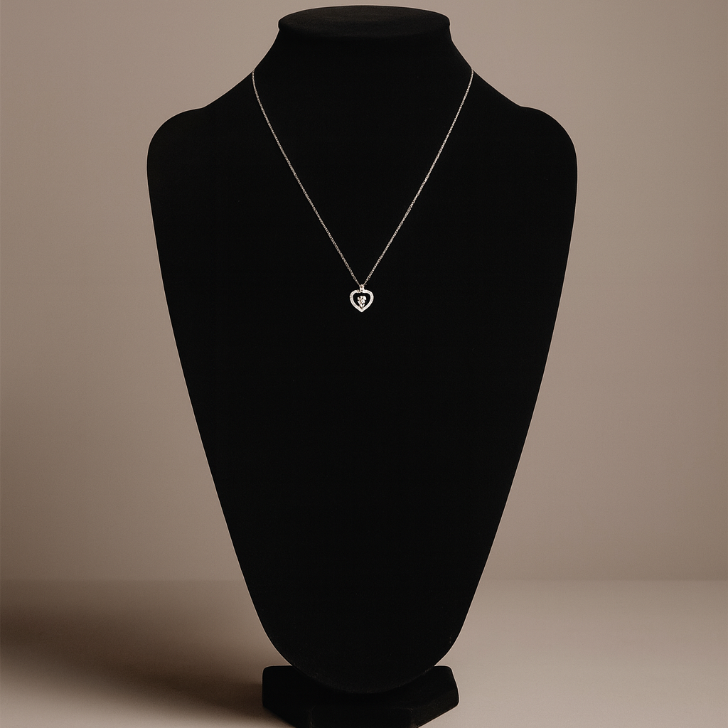 Necklace with a heart pendant on a black mannequin bust against a beige background