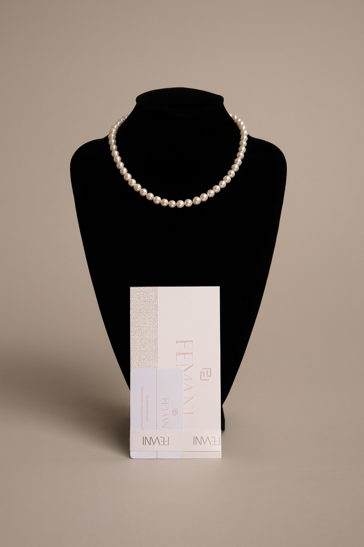 Pearl necklace on a black bust with a beige background