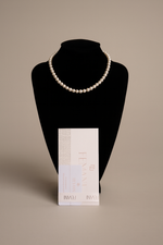 Last inn bildet i gallerivisningen, Pearl necklace on a black bust with a beige background

