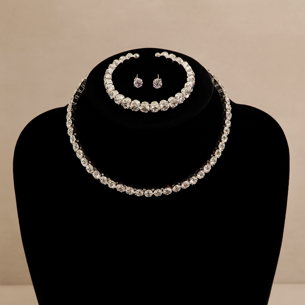 Pearl necklace and earrings set on a black bust against a beige background